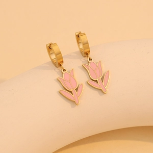 Detail of gold tulip earrings with pink enamel flowers on a minimalist beige stand