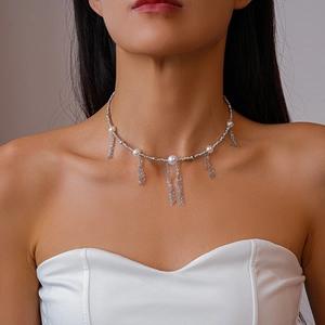 Elegant silver pearl necklace with fringe tassels worn by a model on a clean background
