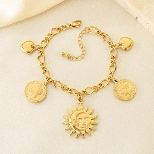 Macro detail of golden charm bracelet with coin and sun pendants on elegant fabric