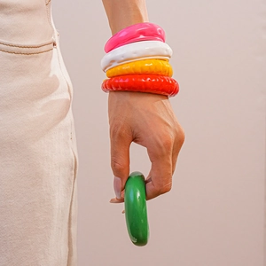 Dettaglio di bracciali in acrilico colorato con trama ondulata e stile moda dopamina