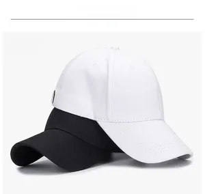 Detailed view of white and black cotton twill baseball caps with stitched eyelets