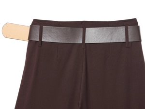 Detailed close-up of high-waist dark brown trousers with matching leather belt detail