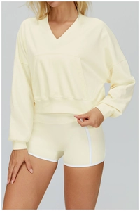 Detail of light beige hooded sweatshirt with V-neckline and practical kangaroo pocket design