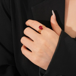 Close-up of vintage oval red zircon ring in gold finish on a model wearing black