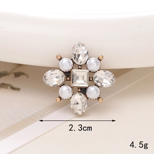 Macro shot of vintage cross charm with white pearls and crystals, size 2.3cm and 4.5g
