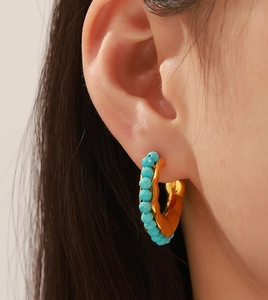 Close-up of Bohemian 18k gold-plated hoop earrings featuring faceted blue bead accents