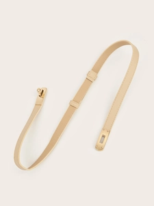 Macro shot of minimalist beige belt with a polished gold turn-lock buckle and cross pattern