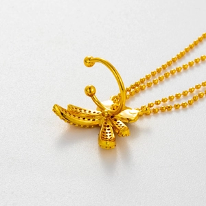 Detail shot of a golden butterfly ear clip with micro-set zircon and bead chain