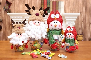 Close-up of Christmas plush reindeer and snowman candy jars on a cozy wooden table