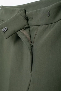 Détail du pantalon vert olive avec braguette zippée, bouton en résine et crochet métal