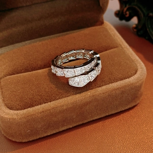 Macro shot of silver snake ring with pavé cubic zirconia on brown velvet background