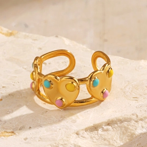 Bague ouverte cœur dorée avec accents en émail coloré sur un fond de pierre naturelle