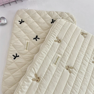 Detailed view of quilted laptop bags featuring cute bow and rabbit head embroidery