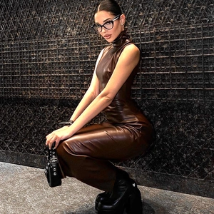 Détail d'une robe en similicuir marron avec fente montrant la texture et l'éclat du tissu