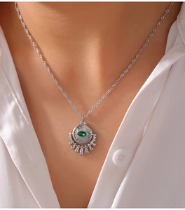 Close-up of silver-tone twisted chain necklace with zircon evil eye and crescent pendant