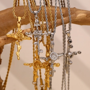 Detail of rose cross necklaces in gold and silver hanging on a rustic wooden branch