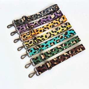 Detailed view of adjustable leopard print nylon bag straps with grey metal lobster clasps