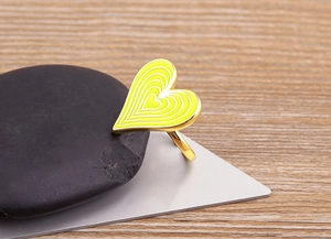 Detail of yellow enamel heart ring in 18K gold plated finish with drip oil technique