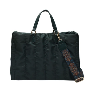 Minimalist green quilted nylon tote bag with patterned shoulder strap on white background