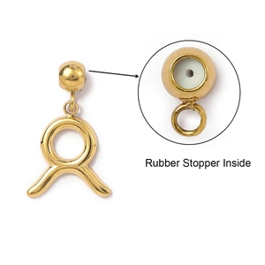 Macro detail of gold Taurus zodiac charm with rubber stopper inside for jewelry DIY