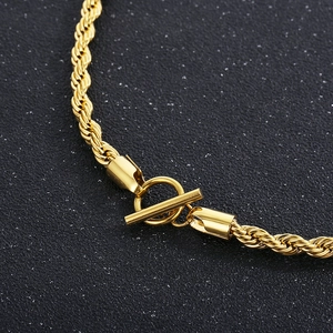 Macro shot of gold twisted chain necklace featuring a textured T-bar toggle clasp detail