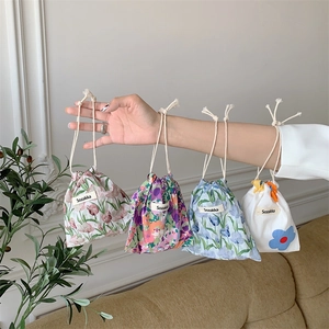 Floral cotton drawstring storage bags in four patterns shown in a cozy home setting