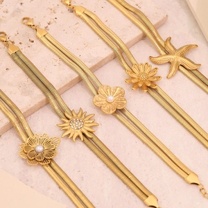 Golden double layer snake chain bracelet with floral sun charms and pearl accents