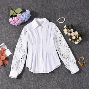 Detail of white button-down shirt featuring intricate lace long sleeves and a crisp collar
