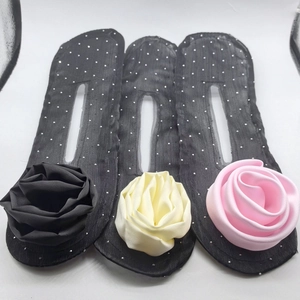 Detail of twisted bun hair maker tool with large fabric rose flowers in three colors