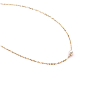 Detailed shot of a gold-plated titanium steel necklace with a round white pearl pendant