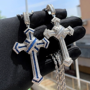 Macro shot of silver cross pendants with blue and white zircons on twist chains