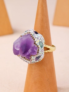 Vue macro d'une bague en améthyste naturelle avec des strass colorés sur anneau doré