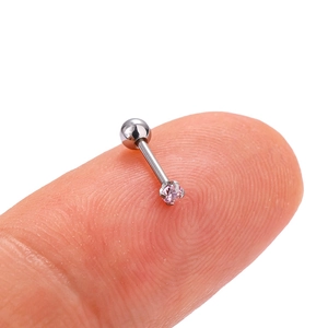 Macro shot of a tiny silver threaded stud earring with a pink zircon on a fingertip