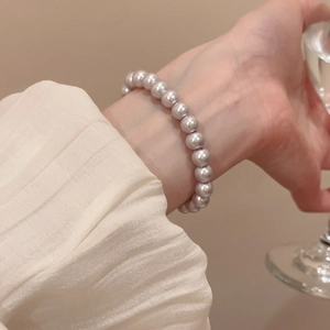 Detailed view of elegant white pearl bracelet on wrist with soft iridescent luster