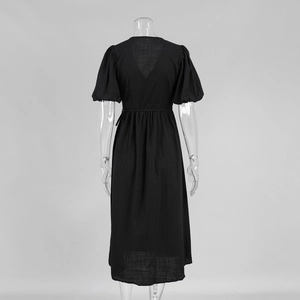 Detailansicht des tiefen V-Ausschnitts und der Puffärmel am schwarzen Midikleid