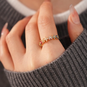 Detailed macro view of 18k gold plated ring featuring colorful pavé-set zircon wave design