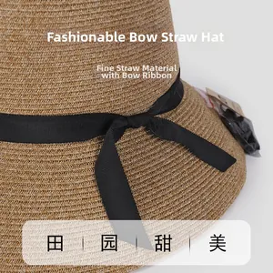 Close-up of fine paper straw weaving texture and black ribbon bow on sun hat