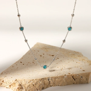 18K gold plated stainless steel necklace with blue turquoise beads on stone display
