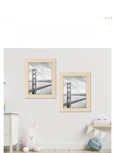 Modern light wood photo frame set in a cozy nursery room with scenic black and white prints