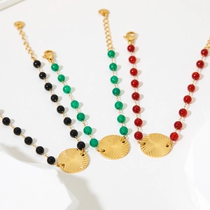 Elegant stainless steel beaded bracelet with gold sunburst pendant in black green and red