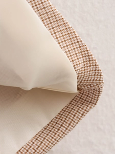 Macro di tessuto pied de poule marrone e bianco con fodera interna beige di classe