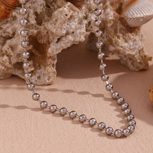 Detail of 4mm silver ball bead chain necklace with polished metallic finish and coral decor