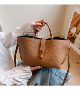 Close-up of brown litchi pattern tote bag featuring gold hardware and slim shoulder strap
