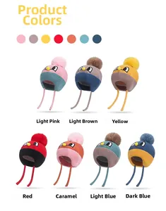 Detail of colorful knitted winter hats for babies with earflaps and cartoon embroidery
