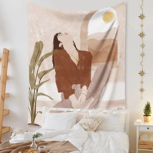 Bohemian wall tapestry with sun and woman art hanging in a cozy minimalist bedroom