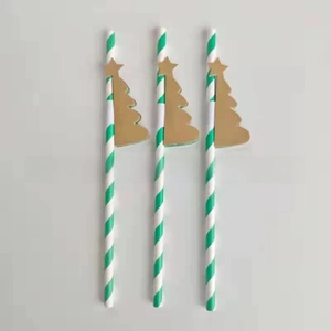 Close-up of green and white striped paper straws with golden honeycomb Christmas tree toppers