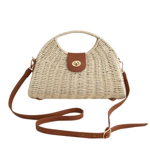 Handwoven summer straw handbag with brown leather flap and adjustable strap for beach vacations