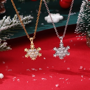 Close-up of gold and silver snowflake necklaces with cubic zirconia in festive decor