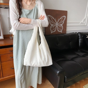 Detailaufnahme von weißem Chiffonstoff mit zarter Blumenstickerei auf der Tragetasche