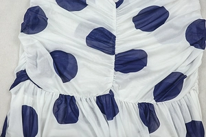 Detailed macro shot of white mesh dress with navy polka dots and ruched texture details